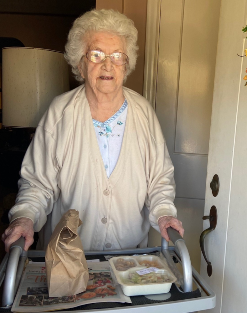 older woman with a walker with a tray sitting on it full of food, aging services in pa